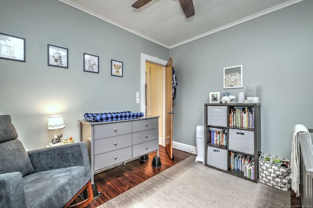 sitting room with wood finished floors, ornamental molding, baseboards, and ceiling fan