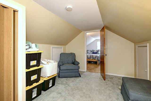 living area with baseboards, vaulted ceiling, and carpet
