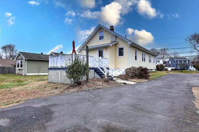 view of front of house with a chimney and a wooden deck