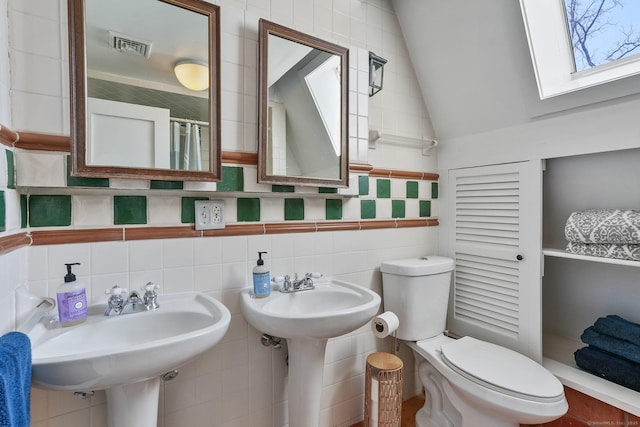 5 Deerfield Rd, Wilton, CT 06897 - bathroom featuring lofted ceiling, a skylight, toilet, tile walls, and a sink