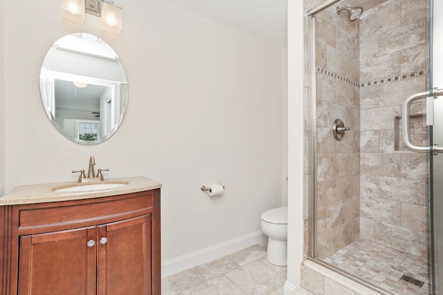 bathroom featuring vanity, a stall shower, baseboards, and toilet