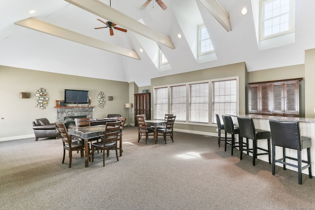 dining area with baseboards, a fireplace, carpet flooring, beam ceiling, and high vaulted ceiling