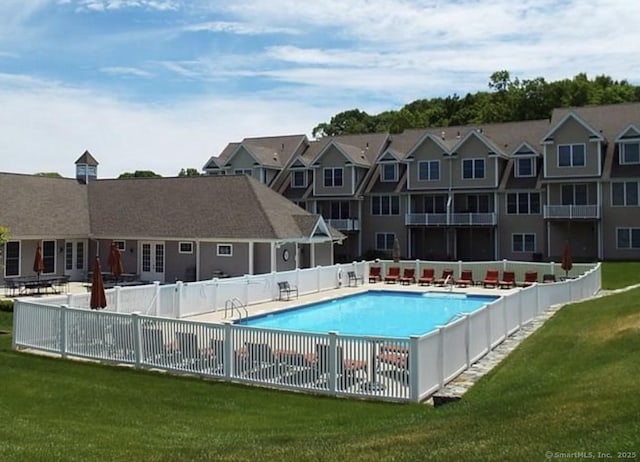 pool featuring a patio area, fence, and a lawn