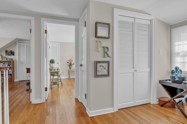 hall featuring baseboards and light wood finished floors