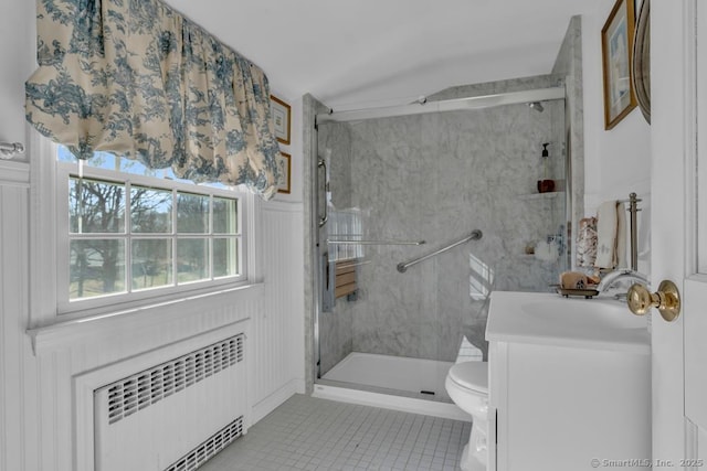 bathroom featuring tile patterned flooring, vanity, toilet, a shower stall, and radiator heating unit