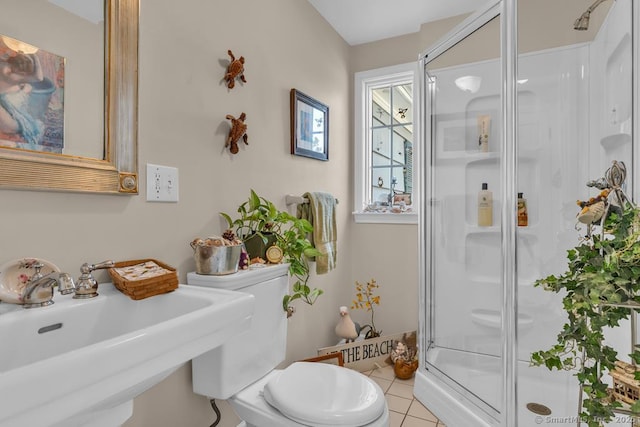 full bath featuring a sink, toilet, tile patterned flooring, and a shower stall