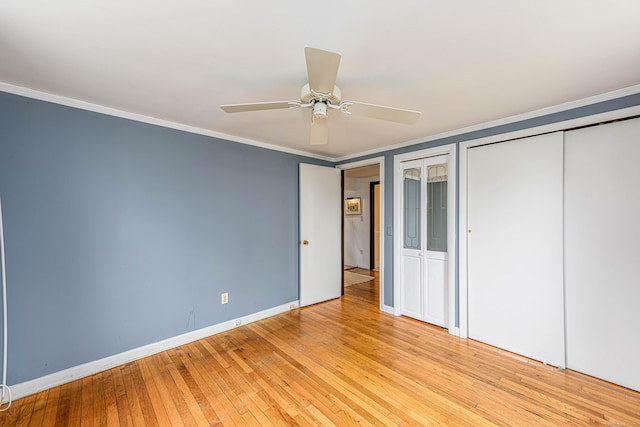 95 Vista Dr, East Haven, CT 06512 - unfurnished bedroom featuring crown molding, multiple closets, baseboards, a ceiling fan, and light wood-style flooring