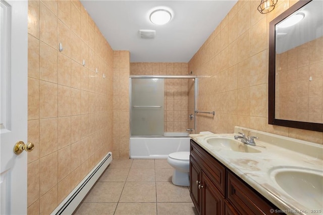 bathroom with tile walls, toilet, a sink, a baseboard heating unit, and tile patterned flooring