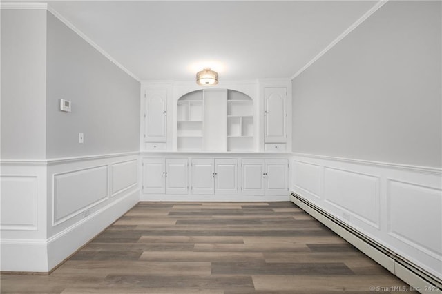 unfurnished dining area featuring wainscoting, wood finished floors, crown molding, and a baseboard radiator