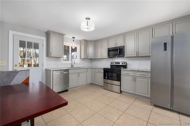 kitchen with gray cabinets, backsplash, and appliances with stainless steel finishes