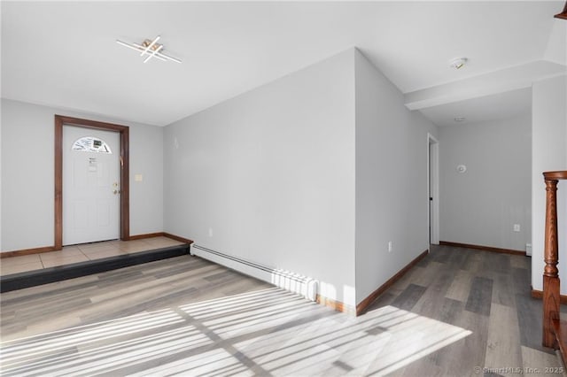 foyer entrance with baseboards, wood finished floors, and a baseboard heating unit