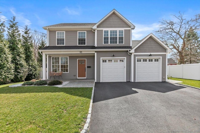 view of front of home with driveway, a front yard, and fence