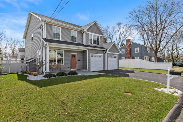 view of front of house featuring driveway, fence, and a front lawn