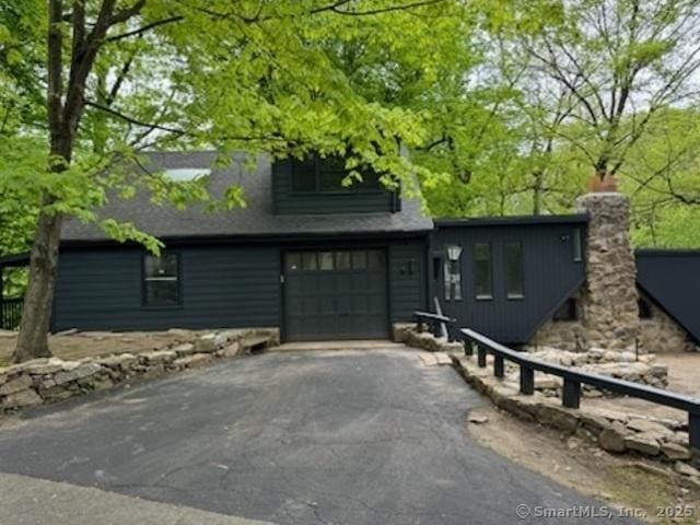 3 Topping Ln, Norwalk, CT 06854 - view of front of house with driveway, an attached garage, and a chimney