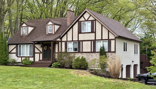 english style home featuring an attached garage, roof with shingles, stucco siding, and a chimney
