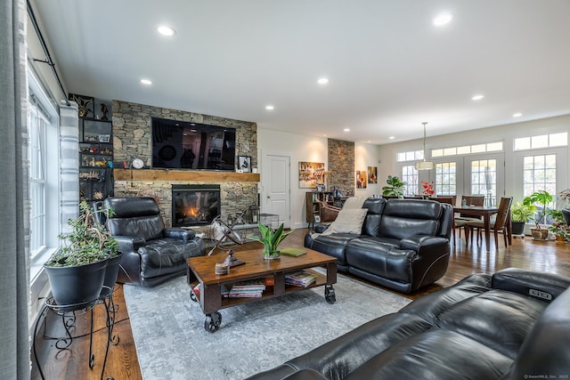 living room featuring wood finished floors, recessed lighting, and a stone fireplace