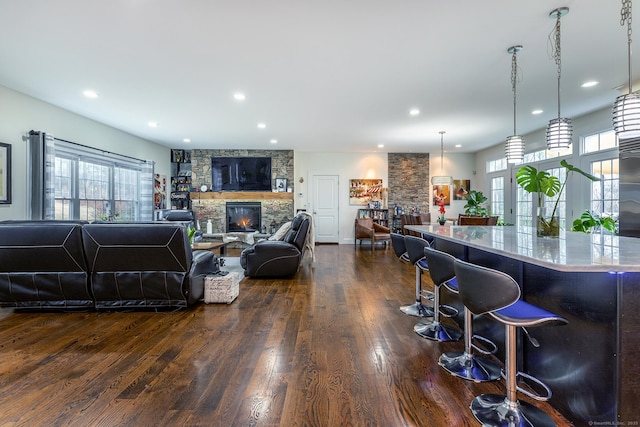 living room featuring a fireplace, recessed lighting, and dark wood-style flooring
