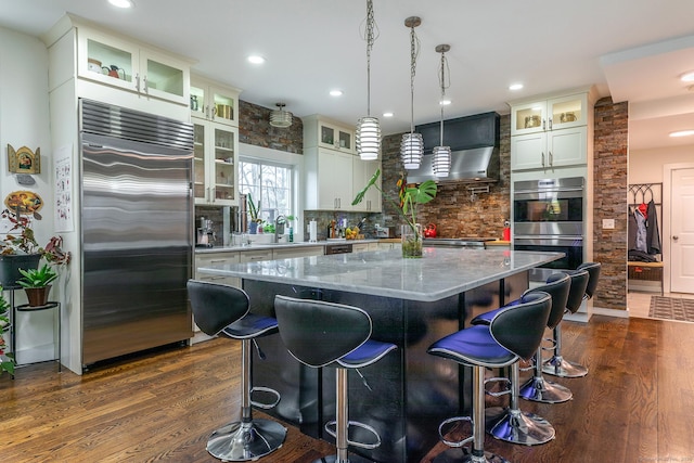 kitchen with dark wood-style floors, a breakfast bar area, stainless steel appliances, and a center island