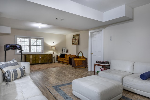 living area with visible vents and wood finished floors