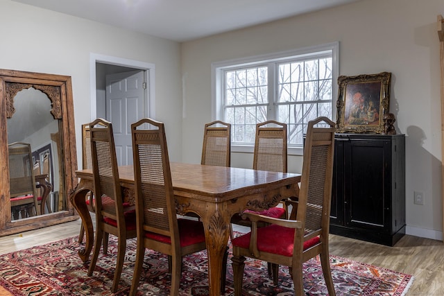 dining room with baseboards and light wood-style flooring