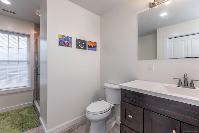 bathroom featuring toilet, vanity, a shower stall, baseboards, and visible vents