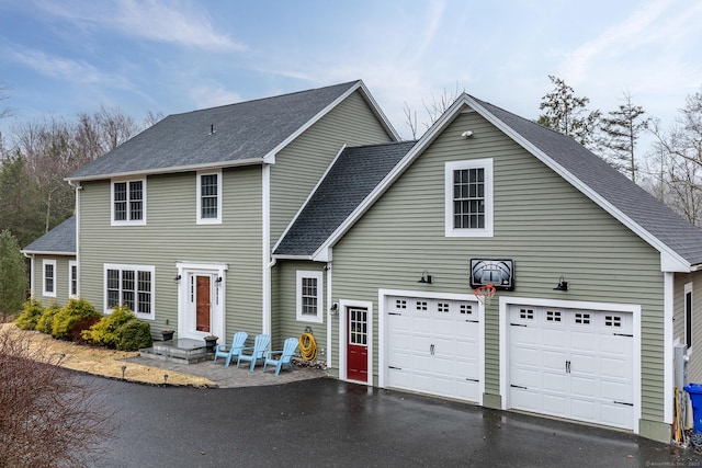 view of front of house featuring a garage, aphalt driveway, and a shingled roof