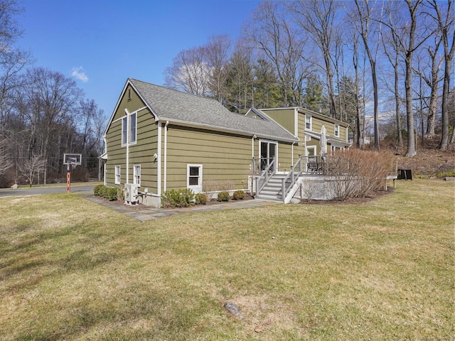exterior space with a front lawn and roof with shingles