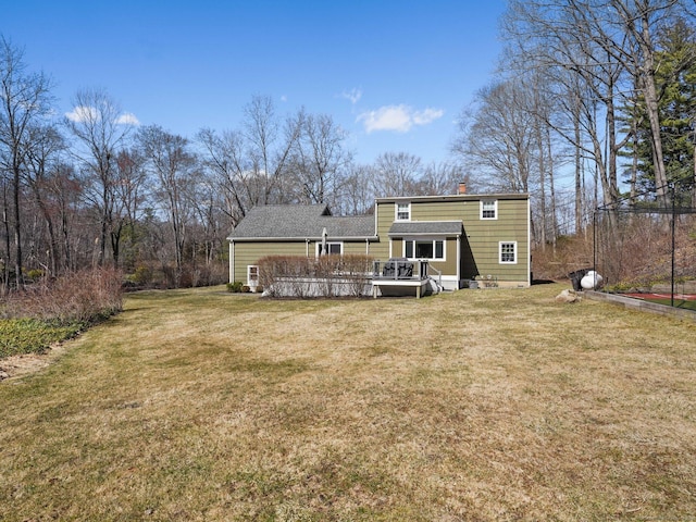 back of house with a chimney, a wooden deck, and a yard