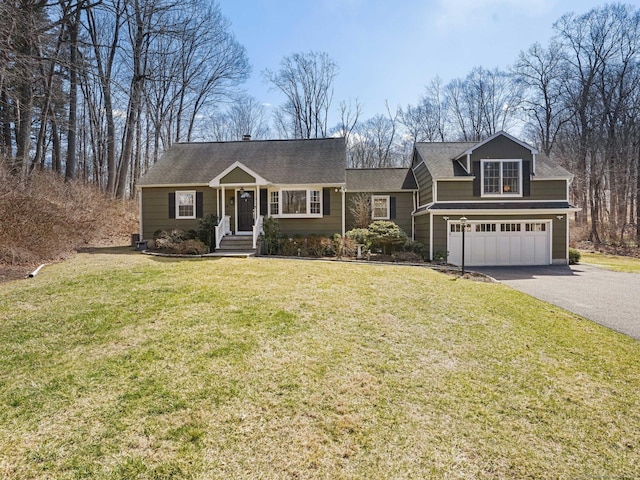 view of front facade featuring a shingled roof, a front yard, a garage, and aphalt driveway