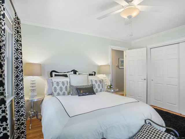 bedroom with a ceiling fan, ornamental molding, a closet, and wood finished floors
