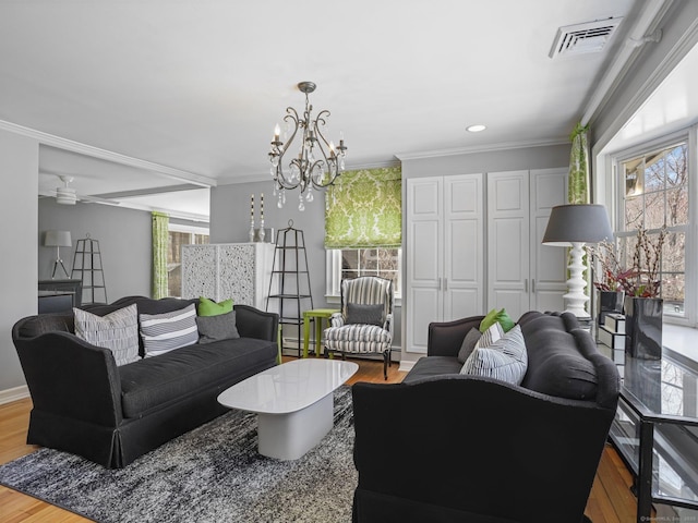 living room featuring wood finished floors, ornamental molding, baseboards, and visible vents