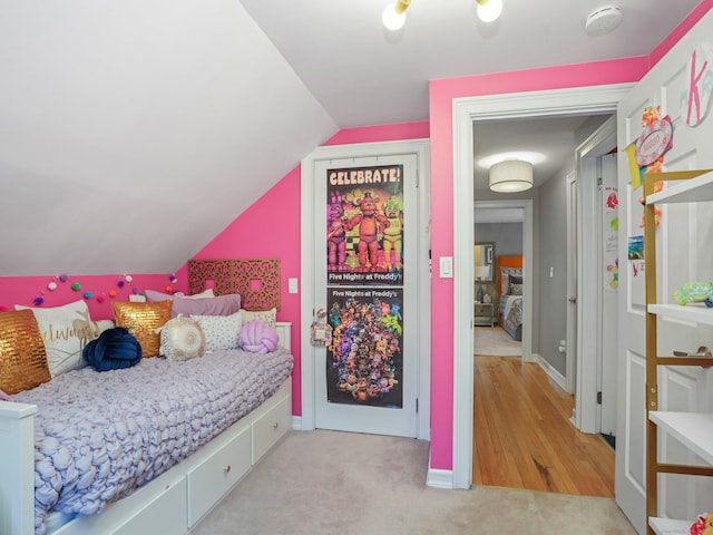 bedroom with light carpet, baseboards, vaulted ceiling, and access to exterior