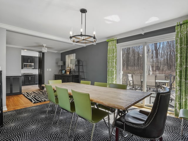 dining room featuring light wood-type flooring, crown molding, and an inviting chandelier