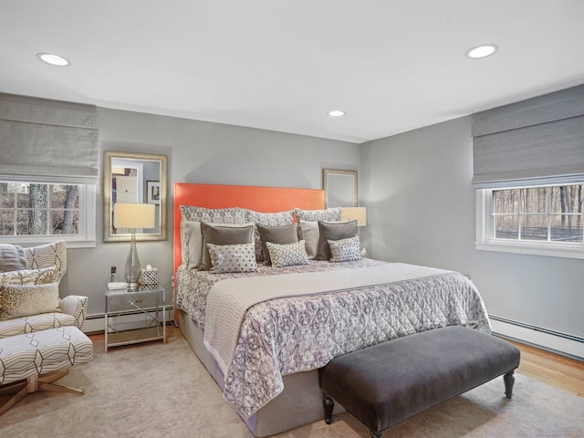 bedroom with a baseboard radiator, wood finished floors, and recessed lighting
