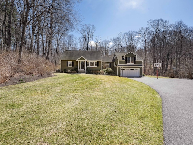 view of front of home with a front yard, driveway, and a garage