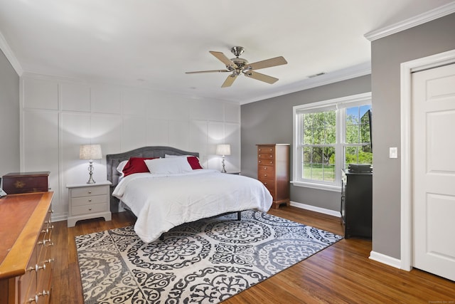 bedroom featuring crown molding, wood finished floors, baseboards, and ceiling fan