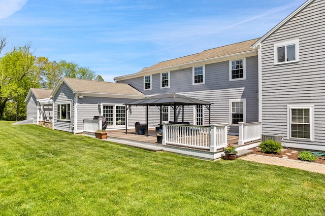 rear view of property with a gazebo, a deck, a lawn, and central air condition unit