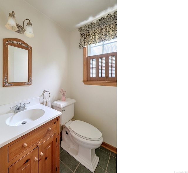 bathroom with baseboards, toilet, tile patterned flooring, and vanity
