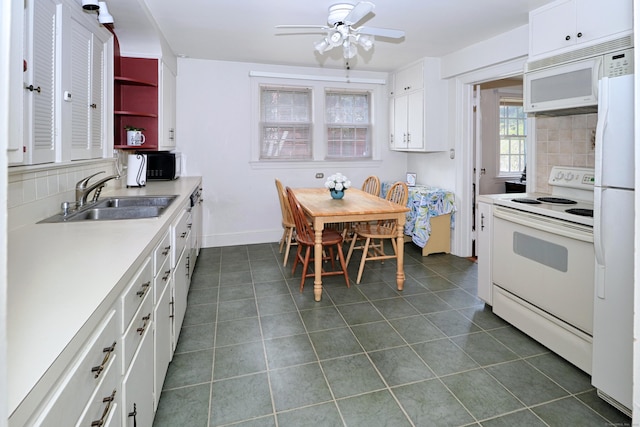 kitchen featuring white appliances, decorative backsplash, dark tile patterned floors, ceiling fan, and a sink
