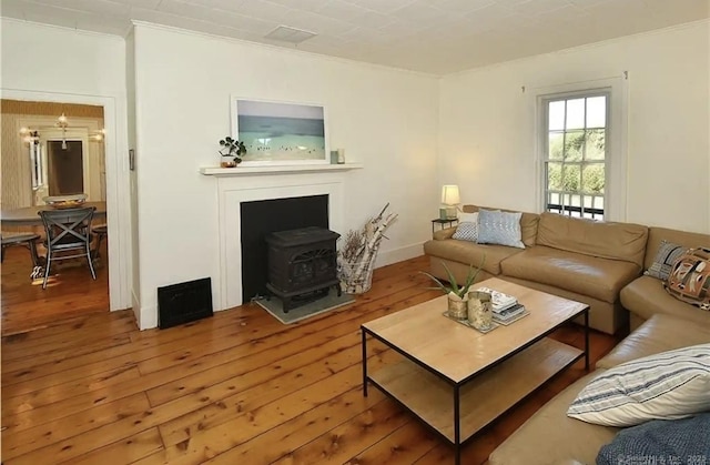 741 Mapleton Ave, Suffield, CT 06078 - living area with ornamental molding, a wood stove, and hardwood / wood-style floors