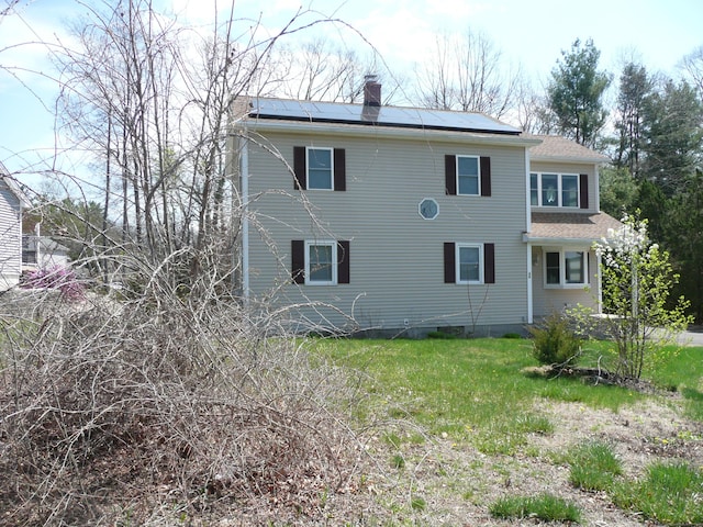 64 Chestnut Cir, Suffield, CT 06093 - back of property featuring solar panels, a shingled roof, and a chimney