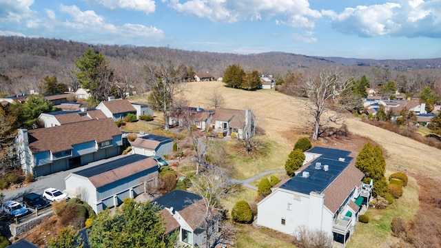 drone / aerial view featuring a residential view and a view of trees