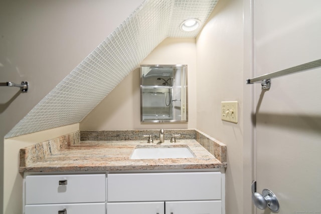 full bathroom featuring vaulted ceiling, vanity, and walk in shower