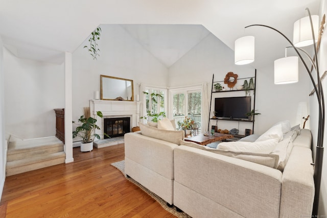 8 Lyle Ct Unit J, Farmington, CT 06032 - living room featuring light wood-style floors, high vaulted ceiling, a glass covered fireplace, and stairs