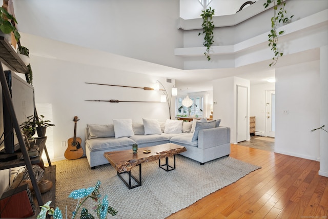 8 Lyle Ct Unit J, Farmington, CT 06032 - living area featuring hardwood / wood-style floors, a towering ceiling, and baseboards