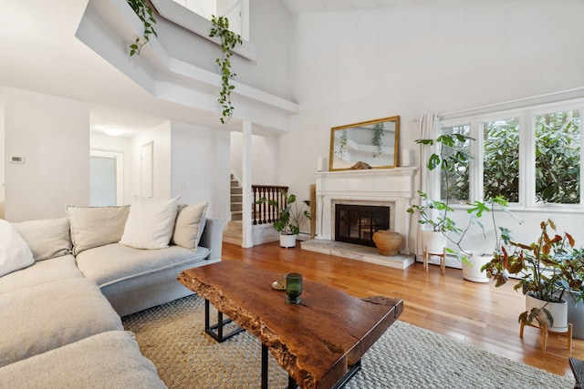 8 Lyle Ct Unit J, Farmington, CT 06032 - living area with wood finished floors, a towering ceiling, stairway, and a glass covered fireplace