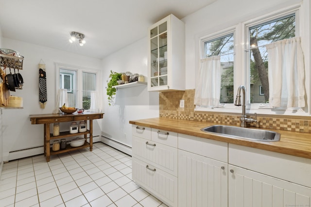 8 Lyle Ct Unit J, Farmington, CT 06032 - kitchen featuring butcher block counters, a sink, a baseboard radiator, tasteful backsplash, and light tile patterned floors