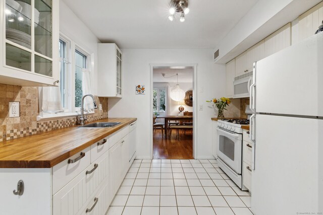 8 Lyle Ct Unit J, Farmington, CT 06032 - kitchen with white appliances, a sink, wooden counters, light tile patterned flooring, and decorative backsplash