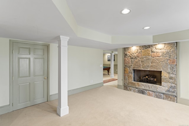 finished below grade area with baseboards, a stone fireplace, carpet, and recessed lighting