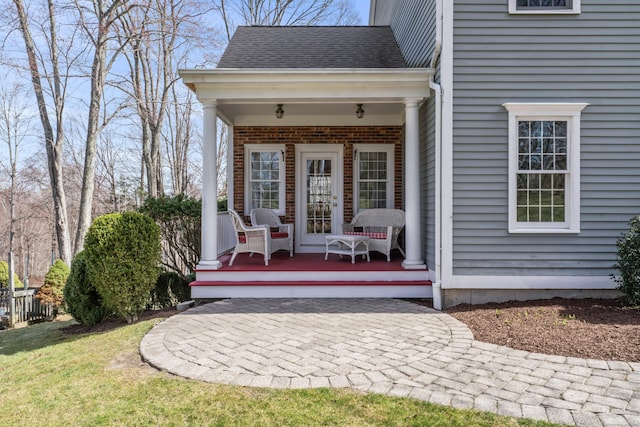 property entrance featuring roof with shingles and covered porch